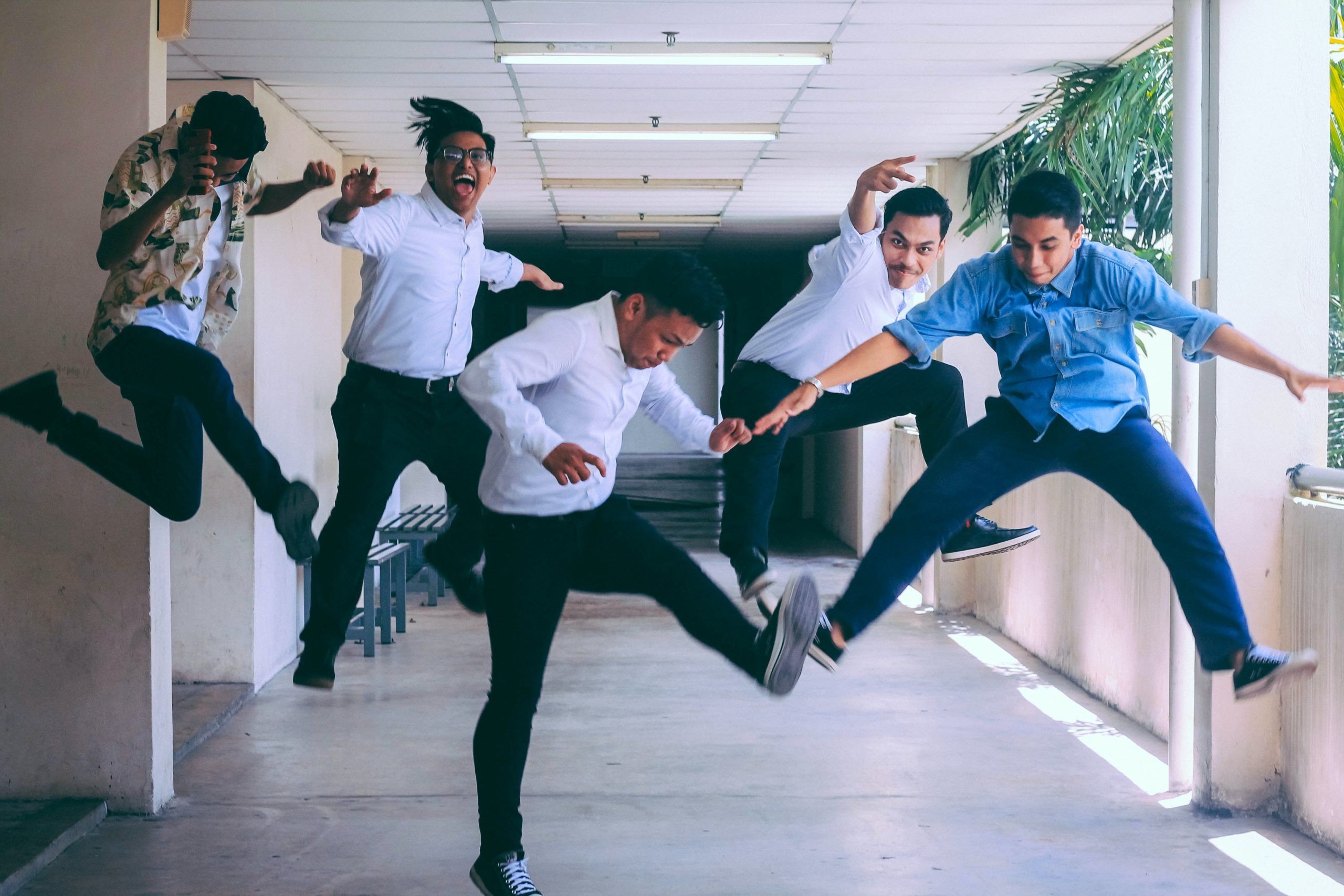 Image of group of men jumping in office building