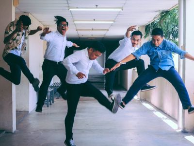 Image of group of men jumping in office building